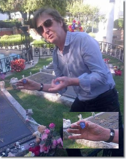 Paul McCartney at Elvis' grave, he is posing as he is holding one of is personalised guitar picks that he is about to leave, 'so Elvis can play in heaven'.